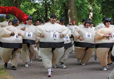 Men and women compete in the quirky annual Sumo Run held on a weekend in June, in Battersea Park, in London, England