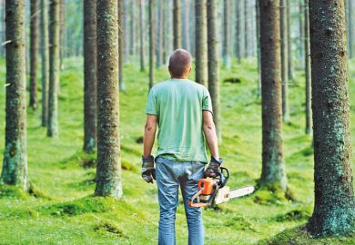 Man holding a chainsaw in a forest