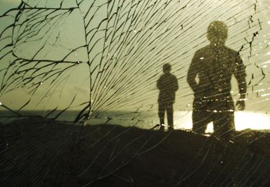 Silhouettes of people behind broken glass