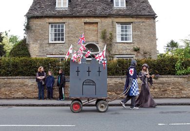 people dressed in medieval costume towing a homemade castle