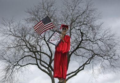 Skeleton wearing graduation gown in a tree. Northeastern Illinois University protest over funding