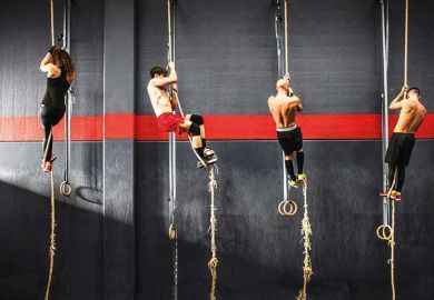 Crossfitters climbing up ropes