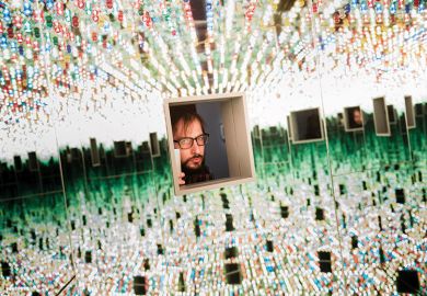 A man looking through a small window at many things