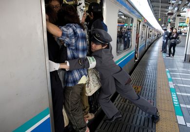 People cram on to a train in Japan