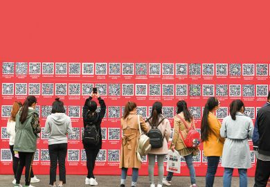 Students in China take pictures of QR codes at a jobs fair