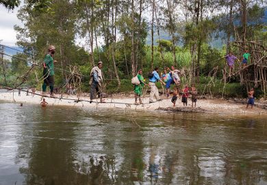 People cross a river in Papua New Guinea