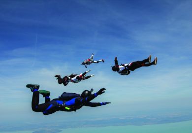 Four young adult male skydivers free falling Four young adult male skydivers free falling