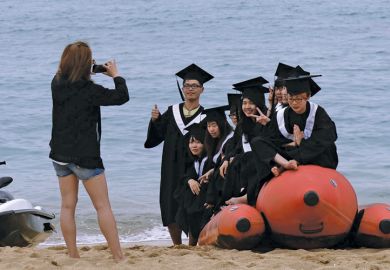 Students on inflatable boat on beach