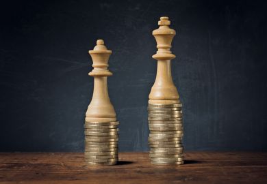 King and Queen chess pieces on pile of coins