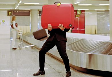 Man holding suitcase in airport