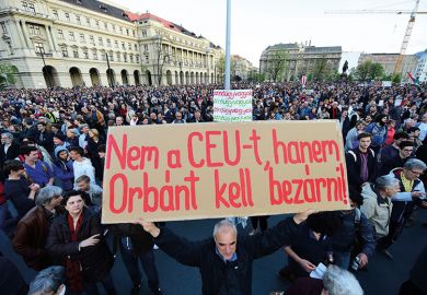 A man holds up a sign with the text 'Don't close CEU, Orban in to the jail" as students and teachers of the Central European University protest. Hungary