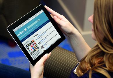 Young woman using Twitter on tablet PC