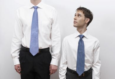 Short business man standing next to tall man