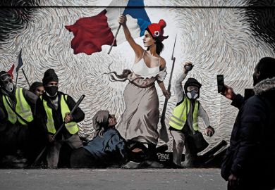 A man takes a picture of a mural by street artist PBOY depicting Yellow Vest (gilets jaunes) protestors inspired by "La Liberte guidant le Peuple" painting by Eugene Delacroix in Paris on January 8, 2019