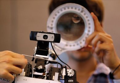 Members of the Rhoban project's team check functions of a humanoid robot at the LaBRI workshop in Talence, southwestern France, July 7, 2014. The humanoid robot, one of four, which is developed by researchers and students from the University of Bordeaux, 