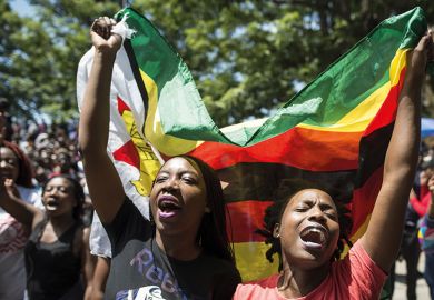 Women holding a flag of Zimbabwe in a demonstration at the University of Zimbabwe