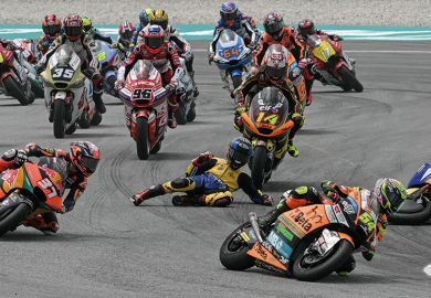 A rider falls to the floor during a motorcycle race  Image of a motorcycle race to illustrate the competitiveness among institutions for August 2024 student recruitment