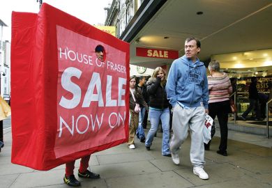 A man dressed as a 'shopping bag' advertises a department stores' post Christmas sales promotions on Oxford Street in central London