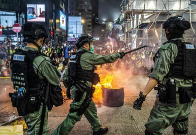 Police stand guard on a road to deter pro-democracy protesters from blocking roads in the Mong Kok district of Hong Kong on May 27, 2020, as the citys legislature debates over a law that bans insulting China's national anthem. 