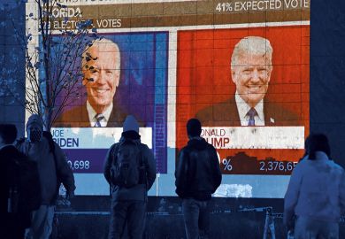 People watch a big screen displaying the live election results in Florida at Black Lives Matter plaza across from the White House on election day in Washington, DC on November 3, 2020.
