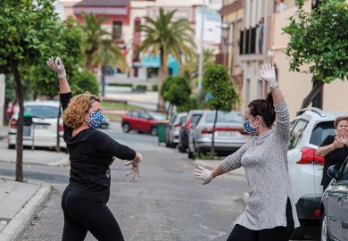 Locals wearing protective mask dance sevillana, a typical flamenco dance, in the street in front of their house April 24, 2020 in Mairena del Alcor, Spain during Covid-19 pandemic