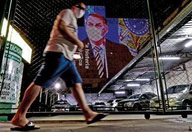 An image of Brazil's President Jair Bolsonaro wearing a protective face mask and the phrase Hysteria Damages the Economy is projected on the wall of a building as a protest against the president regarding his handling of the coronavirus COVID-19 outbreak