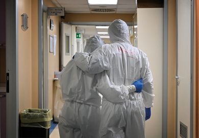 Doctor and nurse at the end of their shift in a corridor of the intensive care unit, treating COVID-19 patients. Italy.