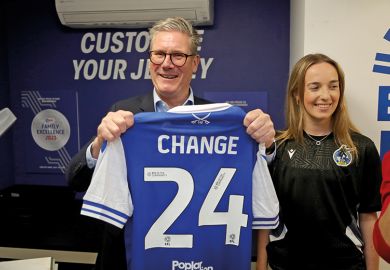 Photo of Sir Keir Starmer holding up a football shirt that says “Change” on it Photo of Sir Keir Starmer holding up a football shirt that says “Change” on it