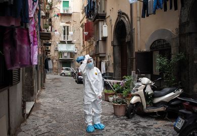 A healthcare worker wearing a protective suit walks through the Quartieri Spagnoli (Spanish Quarters) to screen people for coronavirus (Covid-19) during the pandemic. Italy A healthcare worker wearing a protective suit walks through the Quartieri Spagnoli (Spanish Quarters) to screen people for coronavirus (Covid-19) during the pandemic. Italy