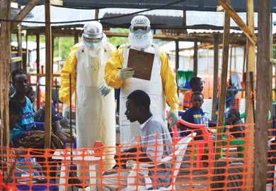 An MSF medical worker, wearing protective clothing relays patient details and updates behind a barrier to a colleague at an MSF facility in Kailahun, 2014. Kailahun along with Kenama district is at the epicentre of the world's worst Ebola outbreak An MSF medical worker, wearing protective clothing relays patient details and updates behind a barrier to a colleague at an MSF facility in Kailahun, 2014. Kailahun along with Kenama district is at the epicentre of the world's worst Ebola outbreak