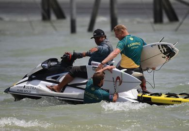 Mick Fanning of Australia (R) helps teammate Matt Wilkinson with his broken board during the qualifiers for the final of the WSL Founders' Cup of Surfing Mick Fanning of Australia (R) helps teammate Matt Wilkinson with his broken board during the qualifiers for the final of the WSL Founders' Cup of Surfing