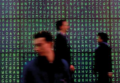 Visitors pass a giant Videoscreen with moving letters symbolising security codes at the computer- fair Cebit in Hanover