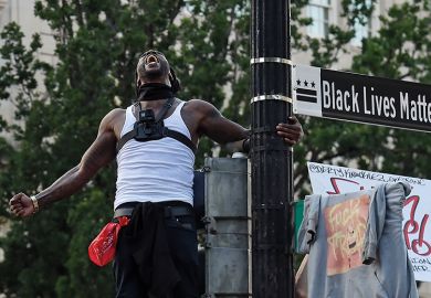 Man screams near a street sign that has been renamed 'Black Lives Matter Plaza' near the White House  during a demonstration against racism and police brutality, in Washing