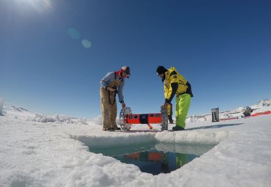 Kevin Hand and Dan Berisford prepare to deploy their under-ice roving robot (BRUIE) through a hole in the sea ice in Antarctica