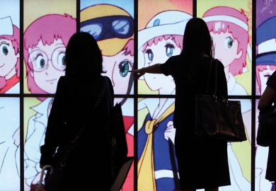 People silhouetted against a screen showing Japanese anime  People silhouetted against a screen showing Japanese anime