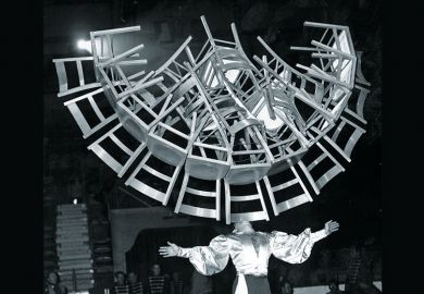 Man balancing lots of chairs