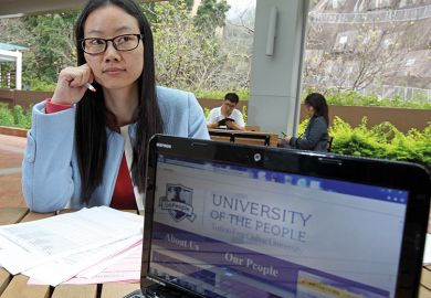 Woman poses with the website of the University of the People in Pok Fu Lam