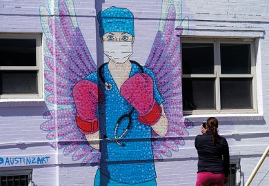 A woman shoots a picture of a mural depicting a medical worker with a mask covering her mouth and nose, wearing boxing gloves and angel-like wings on her back is seen on April 14, 2020 in downtown Denver, United States A woman shoots a picture of a mural depicting a medical worker with a mask covering her mouth and nose, wearing boxing gloves and angel-like wings on her back is seen on April 14, 2020 in downtown Denver, United States