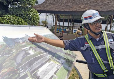 A worker shows an artist rendition of the country's new capital Nusantara A worker shows an artist rendition of the country's new capital Nusantara to illustrate Doubts over higher education vision for Indonesia’s new capital
