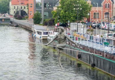 Statue of a tightrope walker crossing a Polish river Statue of a tightrope walker crossing a Polish river