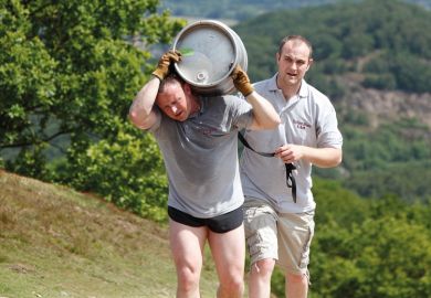 Tired man carrying beer barrel uphill