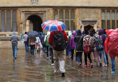 Tourists in rain outside Bodleian Library, University of Oxford