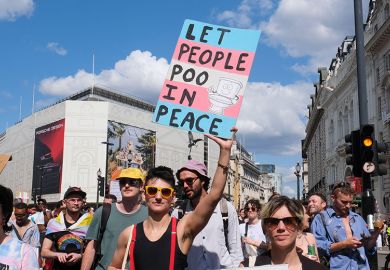 Person holding a sign stating “let us poo in peace” during the Trans Pride march in London, 2024. To illustrate that more UK universities will have to implement policies that restrict the facilities trans people can use after a Supreme Court ruling.