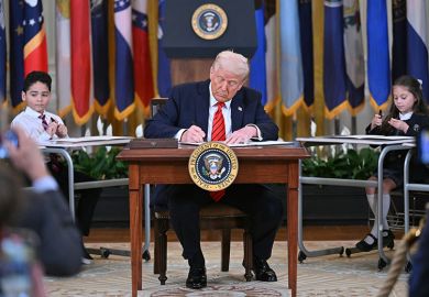 US President Donald Trump signs an executive order during an education event in the White House, Washington, DC, 20 March 2025. Trump signed an order aimed at shutting down the Department of Education, a decades-long goal on the US right.