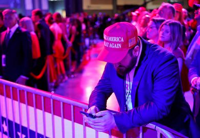 A supporter looks at his phone during an election night watch party for Republican presidential nominee, Donald Trump, at the Palm Beach Convention Center on 5 November 2024.