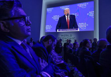 The audience at the World Economic Forum in Davos watch Donald Trump speaking on a big screen