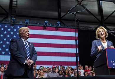 President-elect Donald Trump looks on as Betsy DeVos, his nominee for Secretary of Education, speaks at the DeltaPlex Arena, December 9, 2016 in Grand Rapids, Michigan. President-elect Donald Trump looks on as Betsy DeVos, his nominee for Secretary of Education, speaks at the DeltaPlex Arena, December 9, 2016 in Grand Rapids, Michigan.