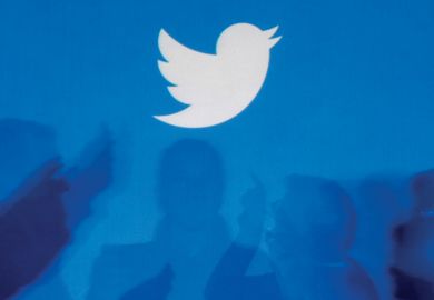 Twitter logo above silhouettes of people in discussion Twitter logo above silhouettes of people in discussion