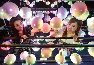 Two women look at pollen robots in Japan Two women look at pollen robots in Japan