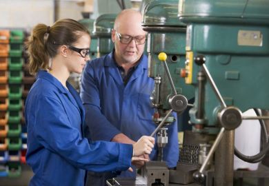 Two machinists working on machine Two machinists working on machine